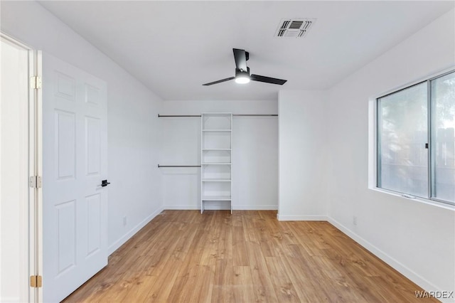 unfurnished bedroom featuring light wood finished floors, baseboards, visible vents, and a closet