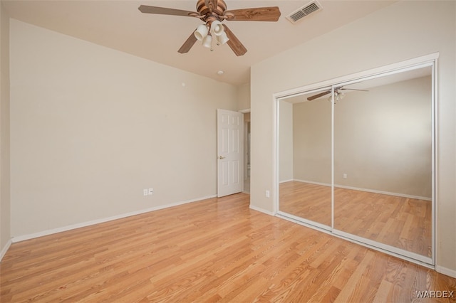 unfurnished bedroom with light wood-type flooring, baseboards, visible vents, and a closet