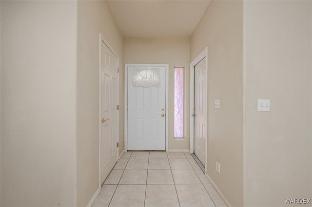 foyer with light tile patterned flooring and baseboards