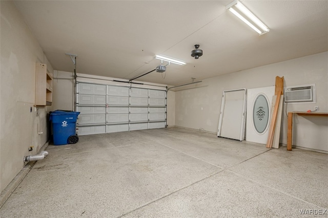 garage featuring an AC wall unit and a garage door opener