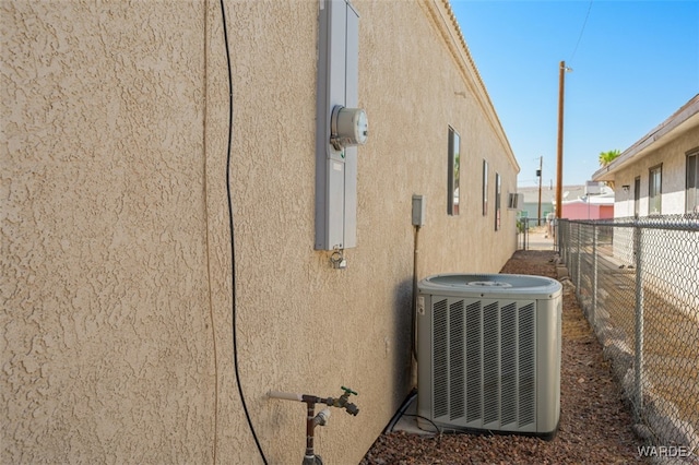 details featuring central AC, fence, and stucco siding