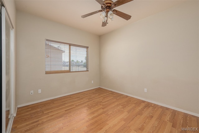 empty room featuring a ceiling fan, light wood-style flooring, and baseboards