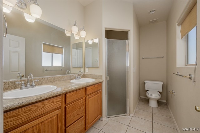 bathroom with double vanity, a shower stall, a sink, and tile patterned floors