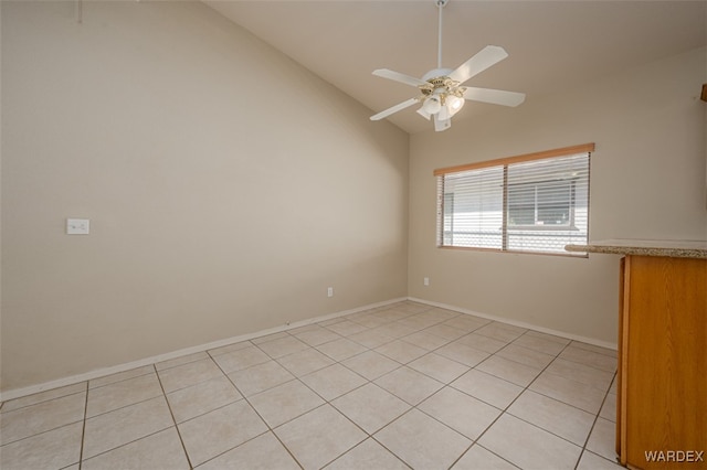 unfurnished room with lofted ceiling, ceiling fan, and baseboards