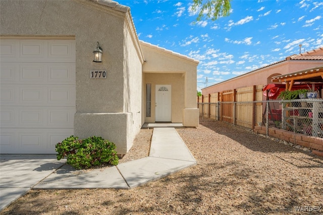 property entrance featuring a tiled roof, fence, and stucco siding