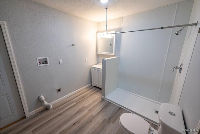 2615 E Devlin Ave, Kingman, AZ 86409 - bathroom with wood finished floors, vanity, a shower, and a textured wall