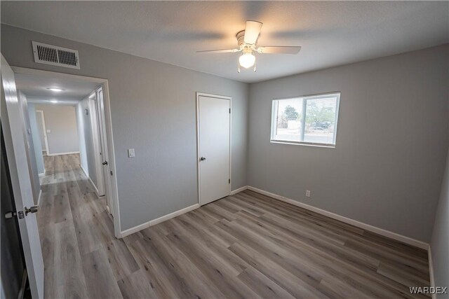 2615 E Devlin Ave, Kingman, AZ 86409 - unfurnished bedroom featuring wood finished floors and a ceiling fan