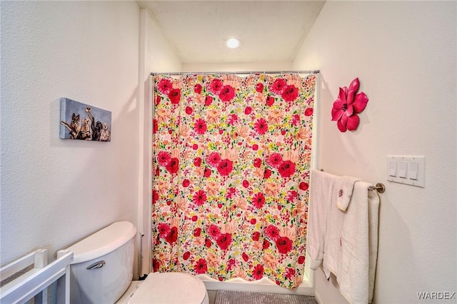 bathroom featuring toilet and a shower with shower curtain