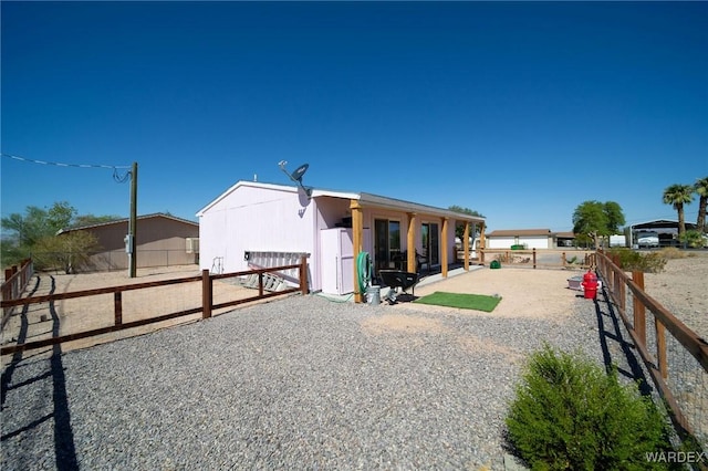 view of front of property featuring an enclosed area, an outbuilding, and an exterior structure