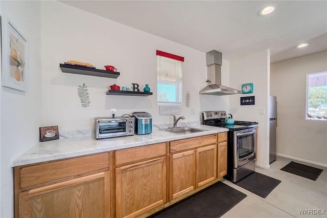 kitchen featuring stainless steel appliances, a sink, baseboards, wall chimney range hood, and open shelves