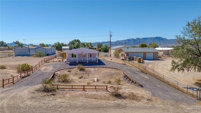 ranch-style home with driveway, fence, and a mountain view