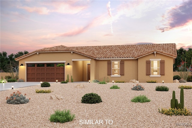 view of front of home with a garage, driveway, a tiled roof, and stucco siding