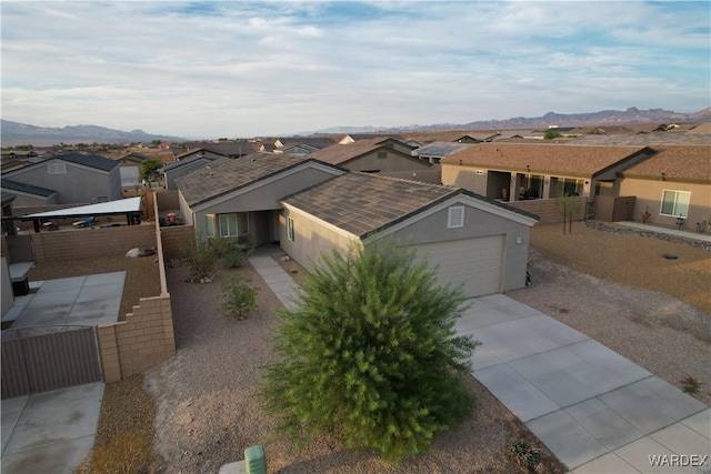 ranch-style house featuring a residential view, a mountain view, and stucco siding