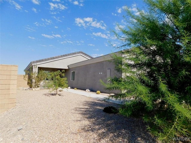 back of property with fence and stucco siding