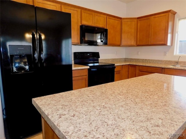 kitchen featuring black appliances and brown cabinets