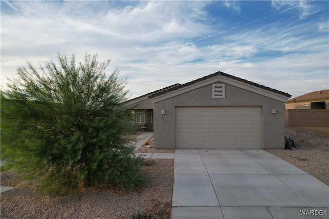 view of front of home with a garage, driveway, and stucco siding