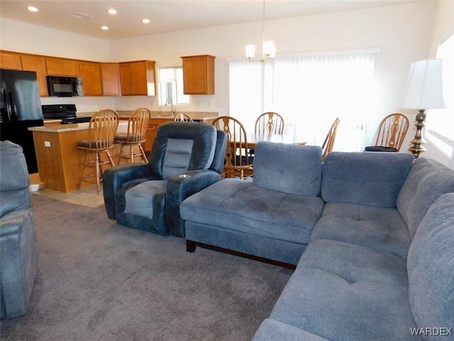 carpeted living area featuring recessed lighting, a sink, and an inviting chandelier