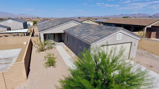 view of front facade with a residential view, a mountain view, and stucco siding