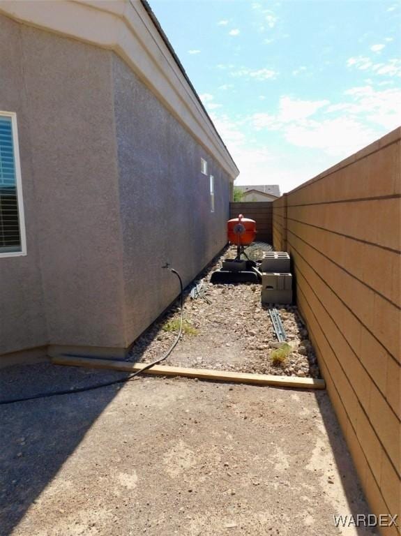 view of side of property featuring fence and stucco siding