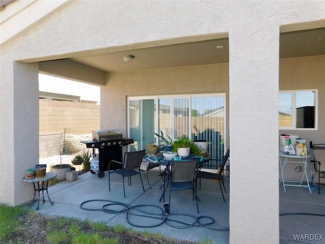 view of patio with outdoor dining space, a grill, and fence