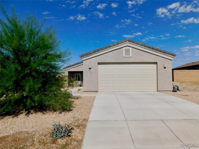 view of front of home featuring an attached garage, concrete driveway, and stucco siding