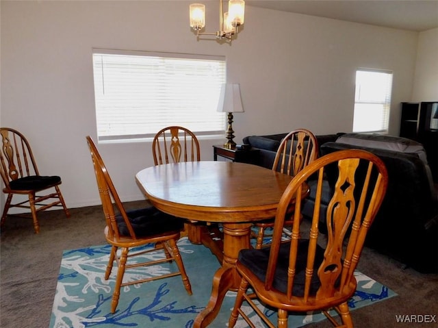 dining space with carpet floors and a chandelier