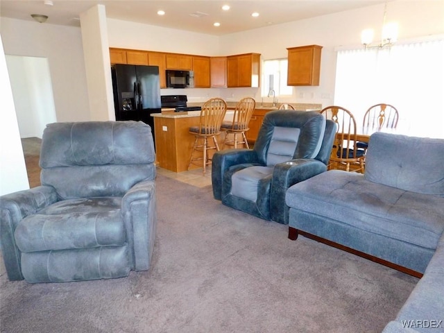 living room with an inviting chandelier, light colored carpet, and recessed lighting