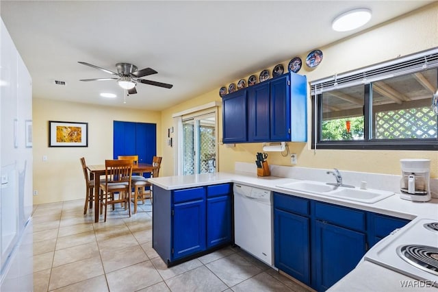 kitchen with white dishwasher, blue cabinets, a peninsula, a sink, and light countertops