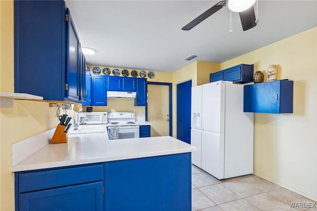 kitchen with blue cabinets, white appliances, visible vents, and light countertops