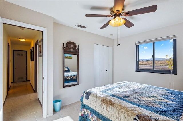 bedroom featuring light tile patterned floors, a ceiling fan, visible vents, and a closet