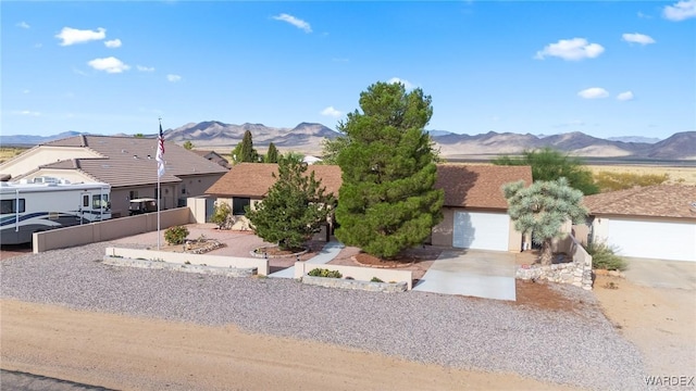 ranch-style home with a garage, fence private yard, a mountain view, and driveway