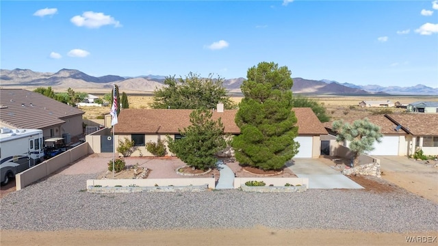 single story home with a residential view, a mountain view, driveway, and fence