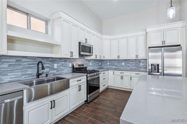 kitchen with decorative light fixtures, open shelves, appliances with stainless steel finishes, white cabinets, and a sink