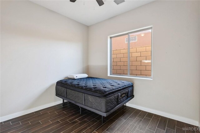 bedroom featuring baseboards, ceiling fan, visible vents, and wood tiled floor