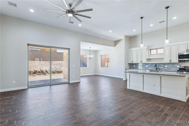 kitchen featuring appliances with stainless steel finishes, white cabinets, light countertops, and pendant lighting