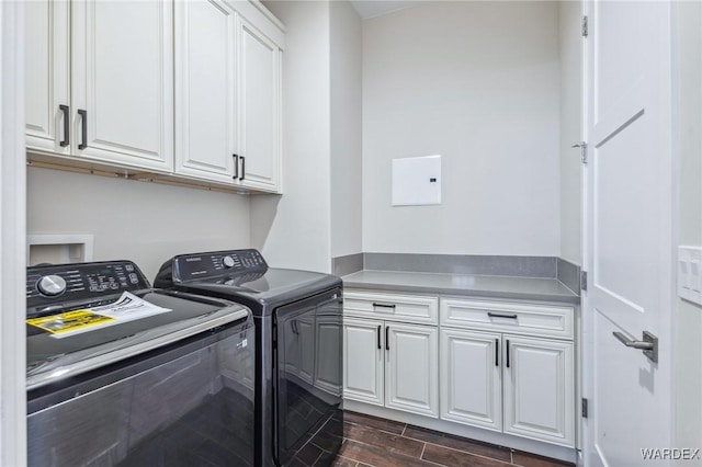 laundry room featuring independent washer and dryer, cabinet space, and wood tiled floor