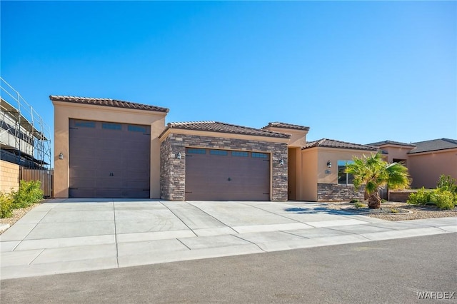 view of front of home featuring stucco siding, an attached garage, stone siding, driveway, and a tiled roof