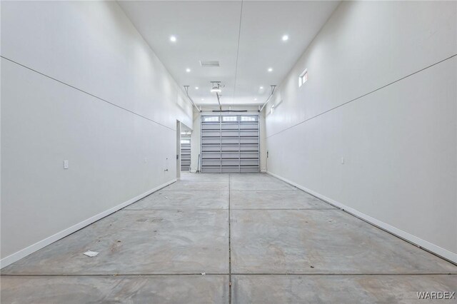 garage with recessed lighting and baseboards