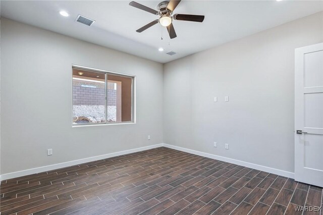 empty room with a ceiling fan, visible vents, baseboards, and dark wood-style flooring