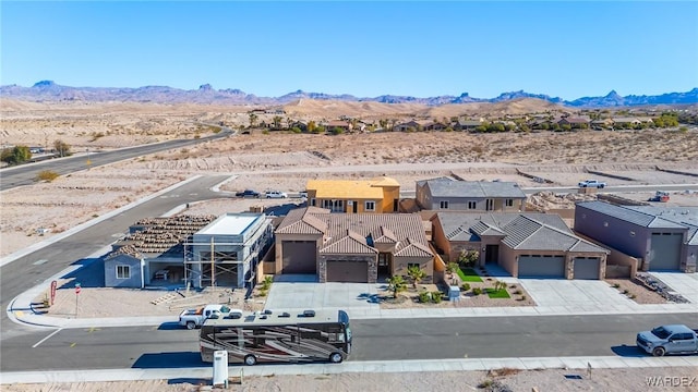 view of front of home featuring a garage, concrete driveway, a tile roof, and a mountain view