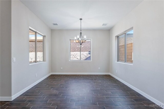 empty room featuring baseboards, visible vents, dark wood finished floors, and a notable chandelier