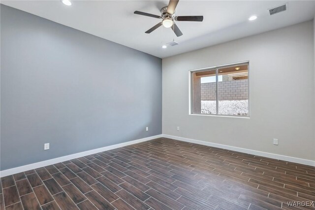 empty room featuring recessed lighting, dark wood finished floors, visible vents, and baseboards