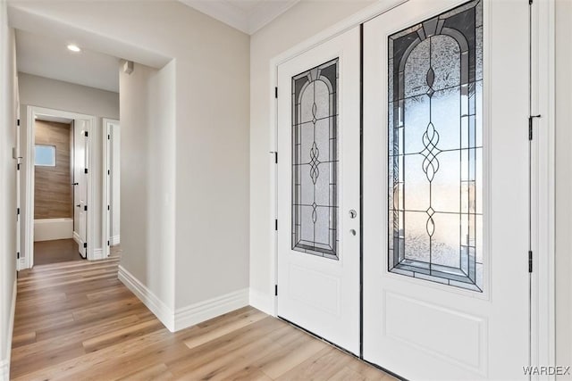 entrance foyer featuring light wood-type flooring, baseboards, crown molding, and french doors