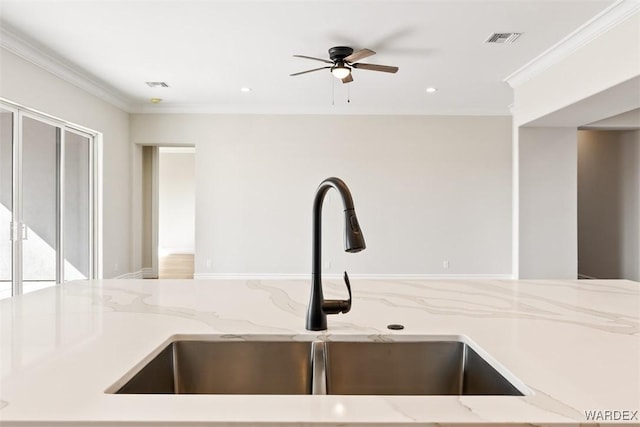 details featuring light stone countertops, visible vents, a sink, and ornamental molding