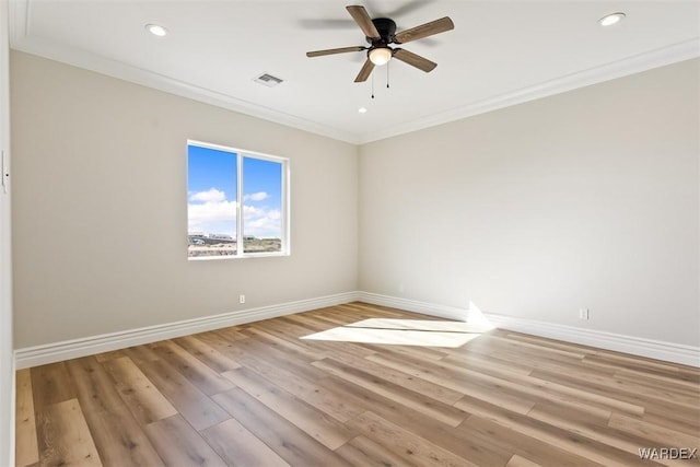 spare room with ornamental molding, visible vents, and baseboards