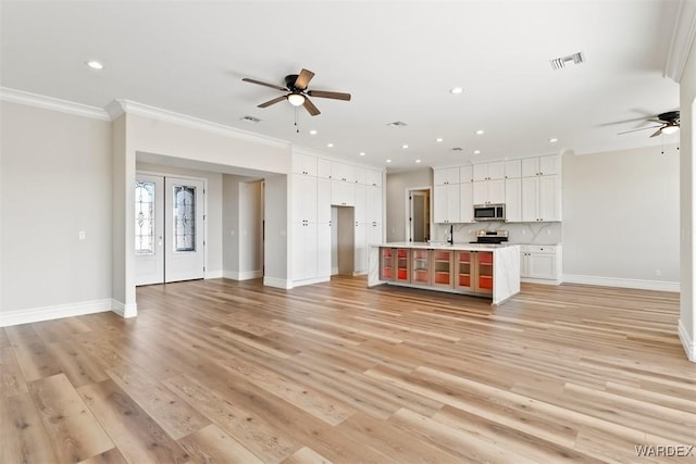 kitchen with open floor plan, light countertops, appliances with stainless steel finishes, and white cabinets