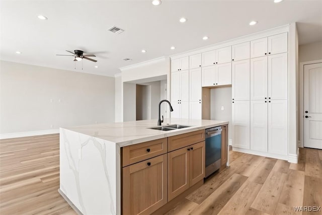 kitchen with a sink, visible vents, white cabinets, dishwasher, and an island with sink