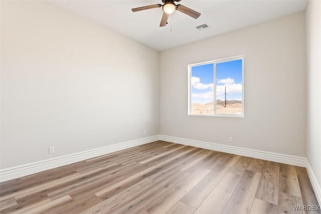 unfurnished room featuring a ceiling fan, baseboards, visible vents, and light wood finished floors