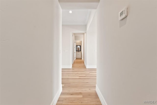 hallway with crown molding, recessed lighting, light wood-style flooring, and baseboards