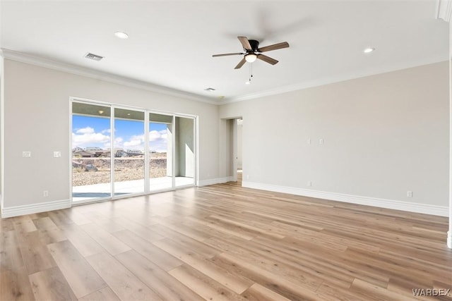 empty room with baseboards, light wood-type flooring, visible vents, and crown molding